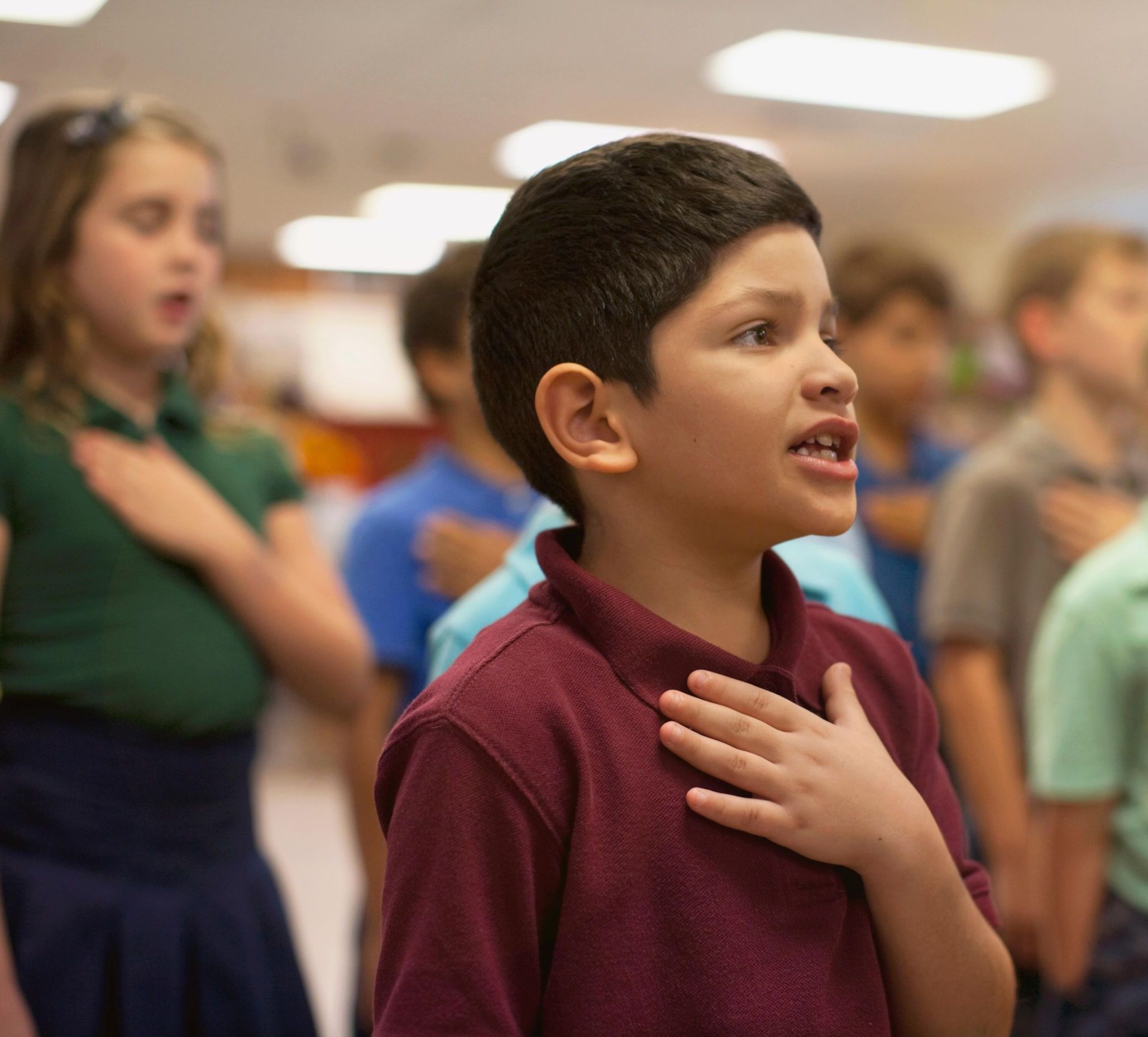 Young children reciting Pledge of Allegiance in school.