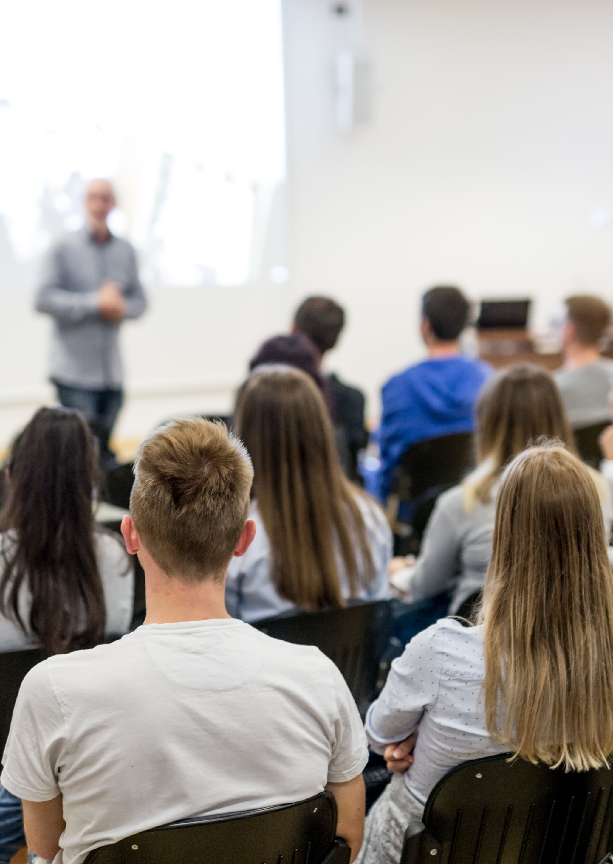 Speaker lecturing a lecture hall full of students at a university.