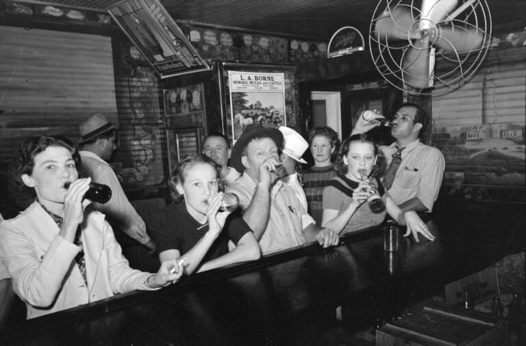 A historical photo from 1938 of men and women drinking beer at a bar on Raceland, Louisiana.