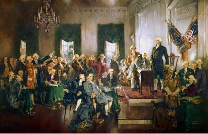 Painting depicting the Constitutional Convention. A large group of men in 18th-century attire is gathered in a grand room. Some are seated, while others stand around George Washington on a raised platform with an American flag in the background.