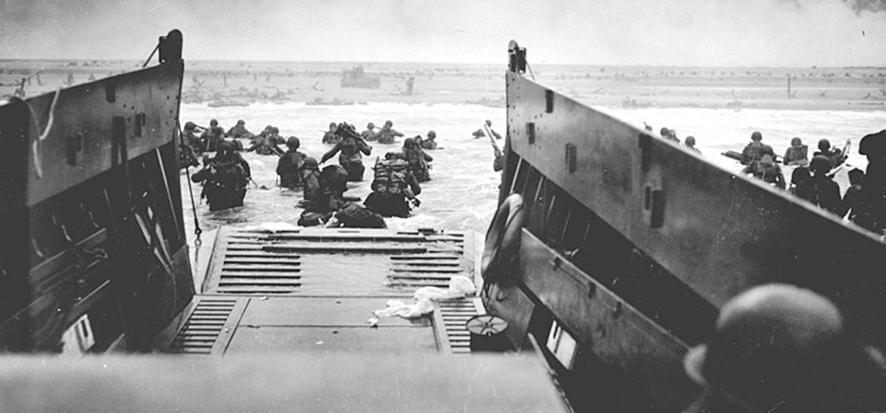 Soldiers getting out of war ships landing at Normandy Beach on D-Day