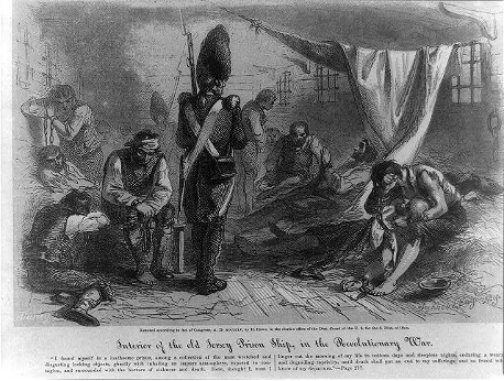 A British soldier standing over several man chained to a ship during the Revolutionary War period