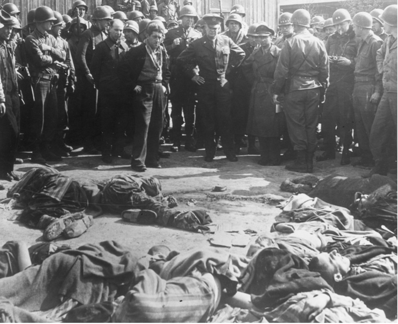 Eisenhower looks at the piles of bodies belonging to Russian and Polish prisoners shot by the Germans at Ohrdruf, Germany (1945).