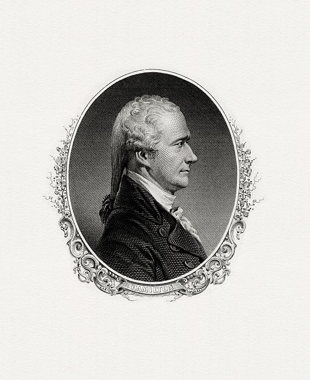 A detailed black-and-white engraving depicts Alexander Hamilton in a side profile view, facing right. He has wavy, shoulder-length hair tied at the back and is wearing a formal, high-collared coat. The portrait is framed by an ornate oval border.