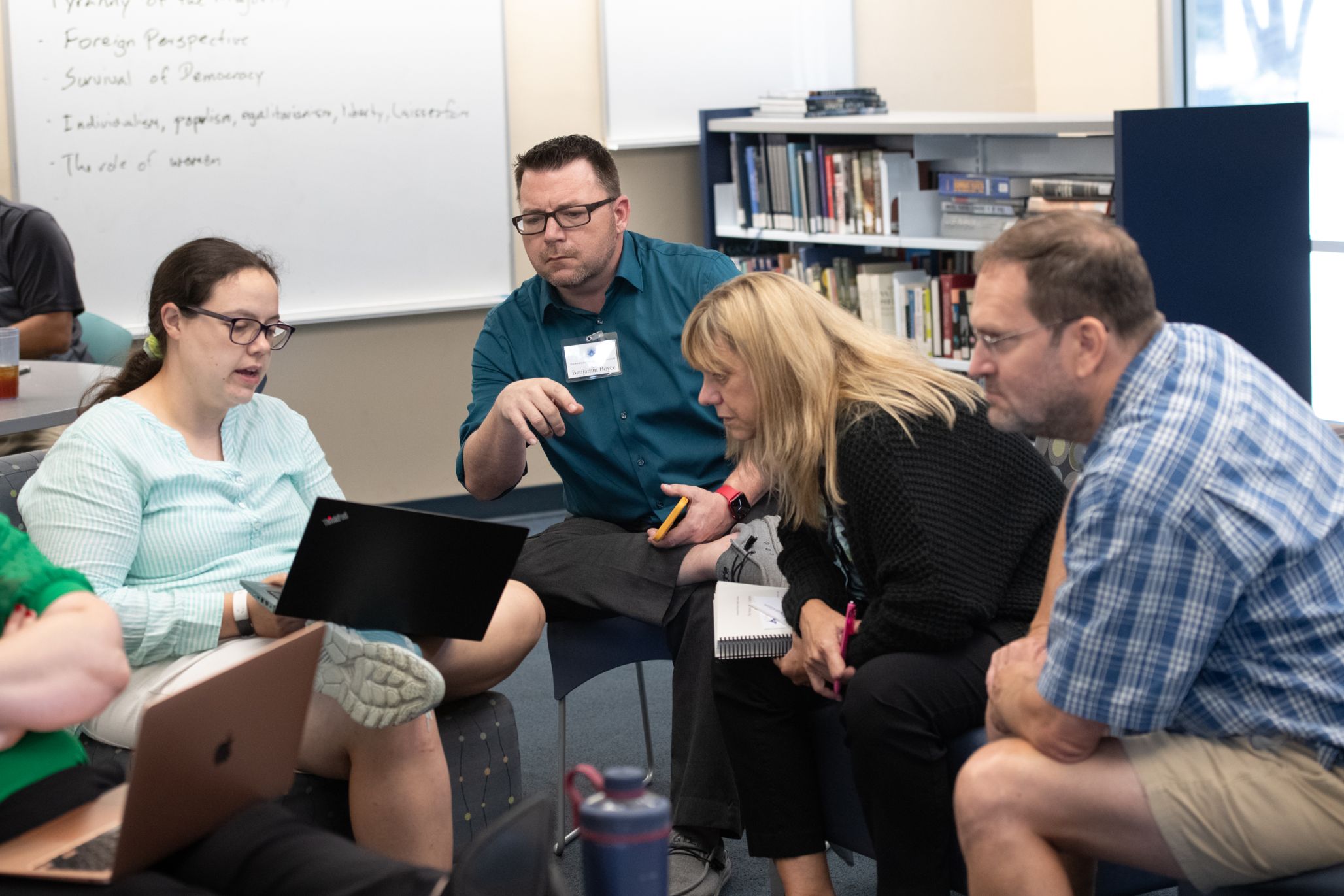 Teachers gathered around a laptop in discussion