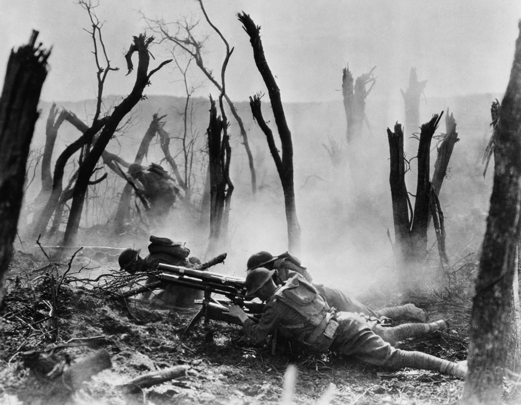 Soldiers on the ground preparing to fire on the enemy surrounded by a barren, wartorn landscape