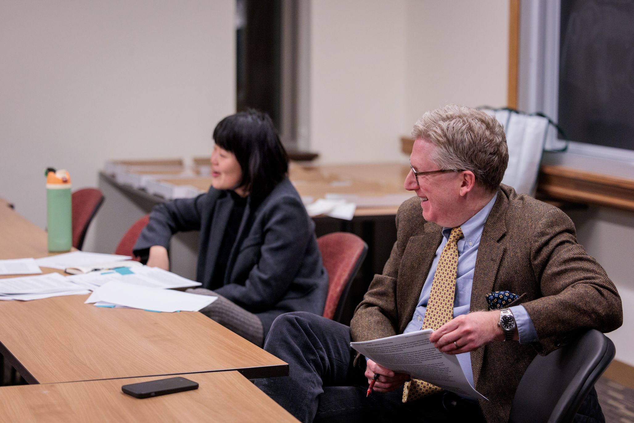 Professors smiling during a Boston College student reading group discussion