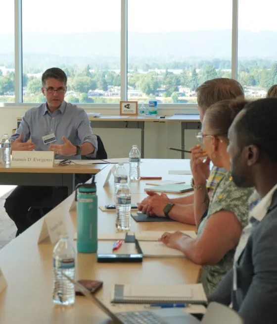 Teachers seated at a table listen to an instructor at the 2023 Community College Conference